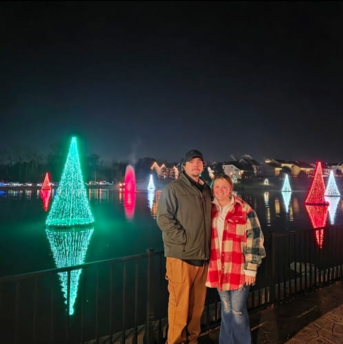 Customer wearing the Red and Green Plaid Shacket at an outdoor Christmas light display.