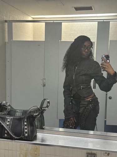 Reviewer taking a mirror selfie, showing the black denim Butterfly Bikini Set's bottom styled over pants.