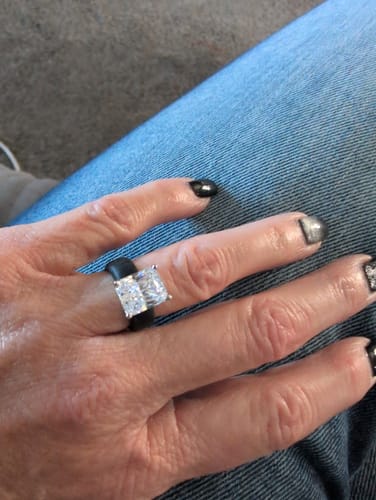 A customer's hand wearing the black Silicone Ring with its brilliant emerald-cut CZ stone.