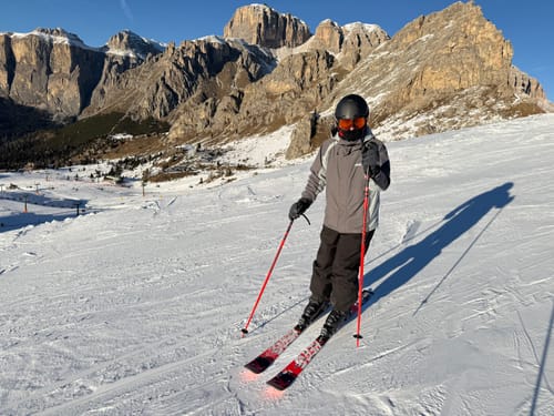 Reviewer skiing on a snowy mountain wearing the black insulated baggy snow pants.