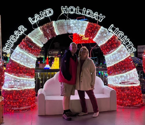Customer wearing the cream Edna Hooded Cardigan at an outdoor holiday lights display at night.