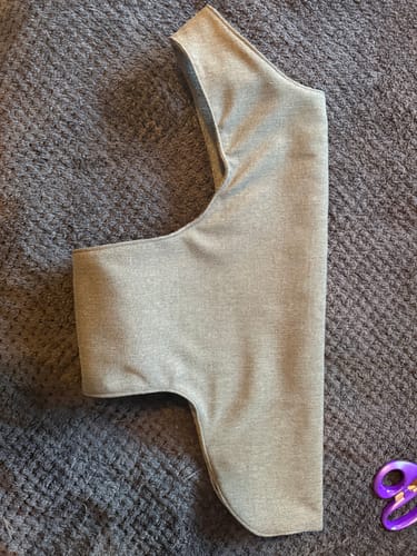 Reviewer's grey fabric scrap from the box, cut into a pattern piece for a dog coat.
