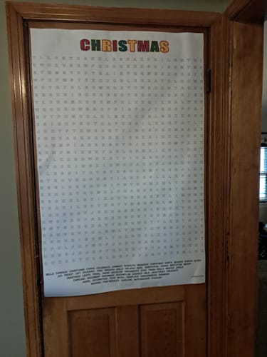 Customer's Christmas Giant Word Search Puzzle hanging on a wooden door in a home.