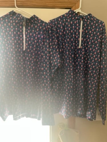 Customer's two identical patterned Transfusion Men's Q-Zip pullovers hanging on hangers side-by-side.