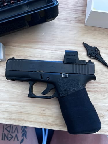 Customer's G43x handgun showing the black Raid Tape wrapped around the grip on a wooden surface.