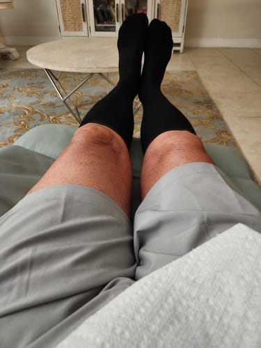 Customer relaxing with their feet up while wearing black Performance Eucalyptus Compression Socks.