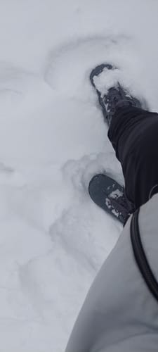 Arvostelijan Vaistoa Uoma 3 Talvi -kengät kävelyllä syvässä lumessa.