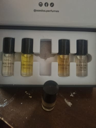Customer's Asēdos Perfume Oil Set with a bottle removed from the box, showing a stained insert from a product leak.