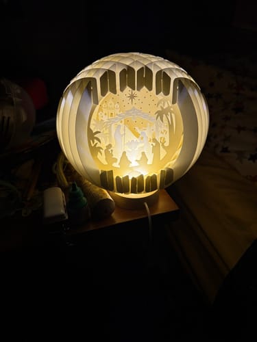 Reviewer's beautiful Nativity Globe Lamp glowing warmly as a nightlight in a dark room.