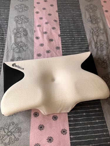 Le coussin d'alignement cervical Cellsius d'une cliente, posé sur un lit.