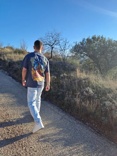 Reviewer from behind wearing the dark Flamenca T-Shirt with a colorful graphic while walking outdoors.