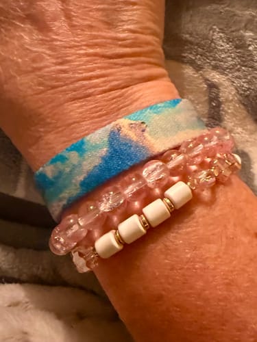 Close-up of a reviewer wearing the Remember Who You Are bracelet, highlighting its blue and white cloud pattern.