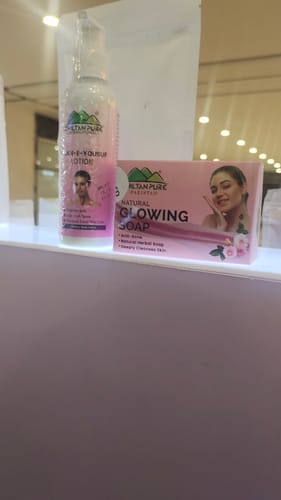 Reviewer's pink box of Glowing Natural Herbal Soap sitting on a white shelf next to another product.