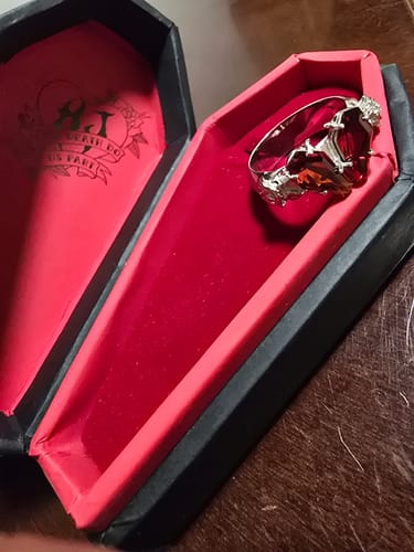 Customer's PROMISE RING inside its open coffin-shaped box with a red interior.