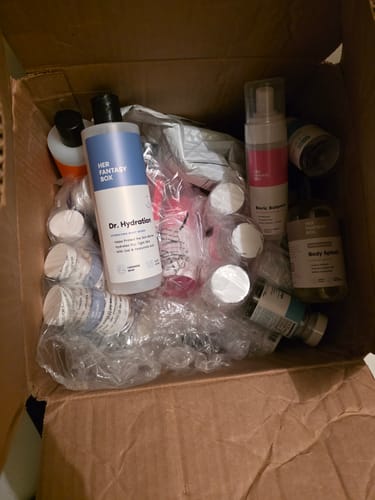 Customer's open box showing products from The Everything Body Care Bundle, including Dr. Hydration wash, mixed with bubble wrap.