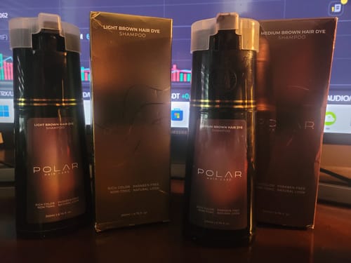 Customer displays two bottles and boxes of Polar Instant Dye Shampoo in Light Brown and Medium Brown shades on a desk.