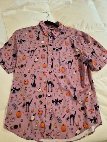 Customer's purple Cats & Bats & Cadies shirt laid out, showing the detailed pattern of cats, bats, and pumpkins.