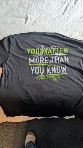 Customer's black Know Your Worth tee laid out, showing the back text 'YOU MATTER MORE THAN YOU KNOW' in green and grey.