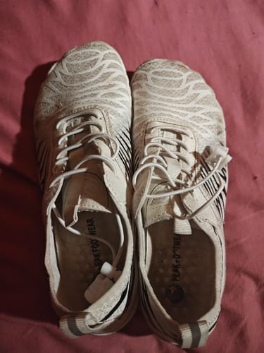 A customer's pair of white Lorax Pro barefoot shoes with a textured wavy pattern, seen from above.
