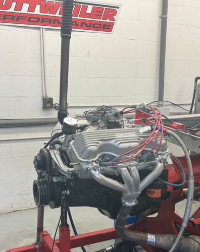 Customer's engine on a stand in a workshop, with a Motion Raceworks Billet Valve Cover Breather installed.