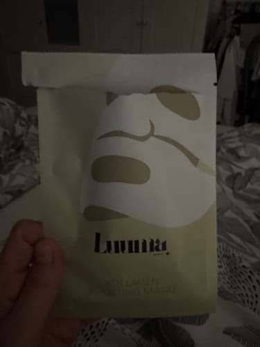 Ein Rezensent hält die Verpackung der Kollagen Boosting Maske in der Hand.