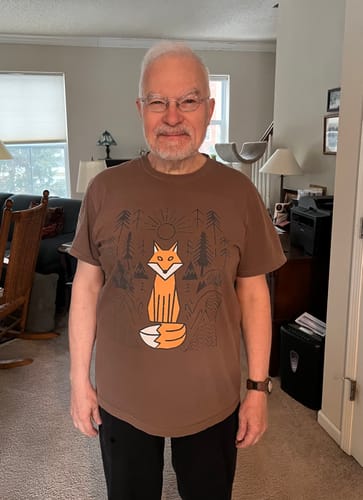 Reviewer wearing the brown Fox Spirit T-Shirt with a graphic of an orange fox in a forest.