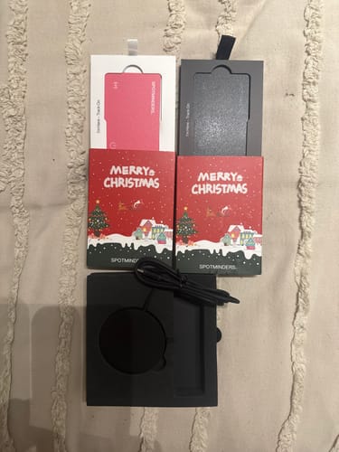 Reviewer's two SPOTMINDERS chargers in festive packaging, one pink and one black.