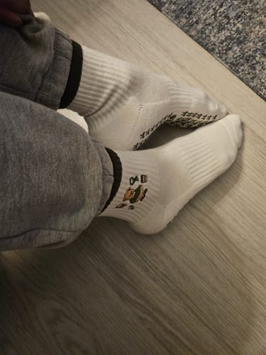 Customer's feet in white Merry Beary socks, showing the cute bear graphic on the ankle.