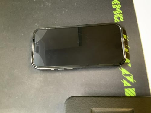 Kunde zeigt, wie sich die Schutzfolie an der Ecke des iPhones löst, wenn sie mit einer Hülle verwendet wird.