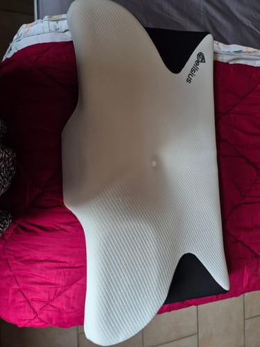 Le coussin d'alignement cervical Cellsius d'un client, posé sur un lit.