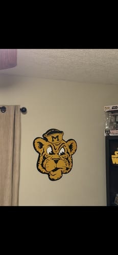 Reviewer's Missouri Tigers vintage metal wall art hanging on a light-colored wall in a room.