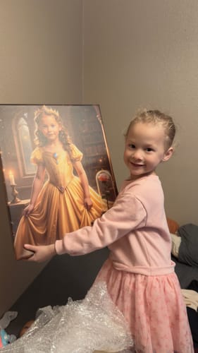 Customer holding the 'The Beauty and the Enchanted Rose' custom portrait featuring a girl in a yellow gown.