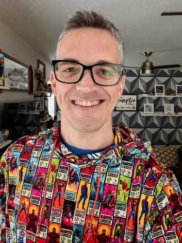 Reviewer smiling while wearing the colorful Marvel "Corner Box Brigade" Performance Hoodie.
