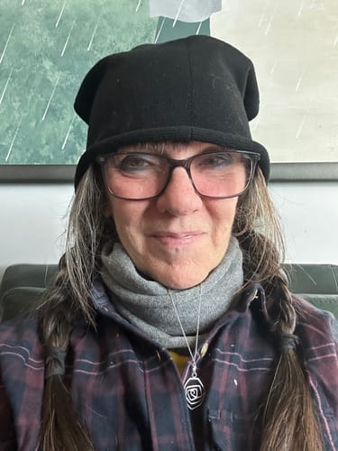 Close-up of a reviewer wearing the black knitted hat, showing its casual droop as mentioned in the review.
