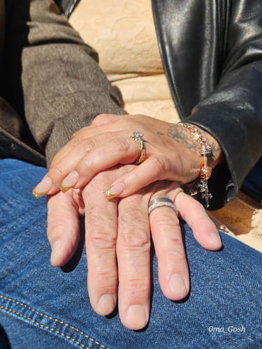 Customer wearing The Whitetail ring on their finger, holding hands with another person in the sunlight.