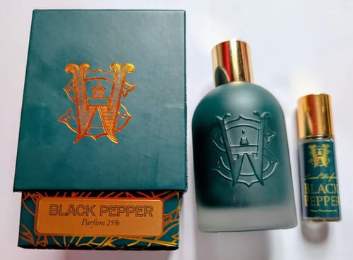 Reviewer's teal Black Pepper perfume shown in two sizes next to its box.