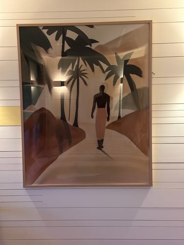 Customer's close-up of the framed Palmora I art print hanging on a white paneled wall, showing muted colors.