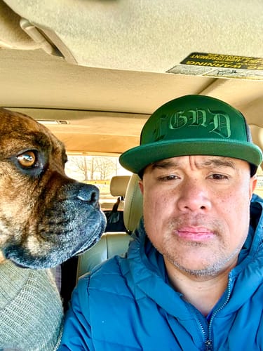 Reviewer in a car wearing the green Forest Seven Panel Trucker Cap, showing the flat bill.