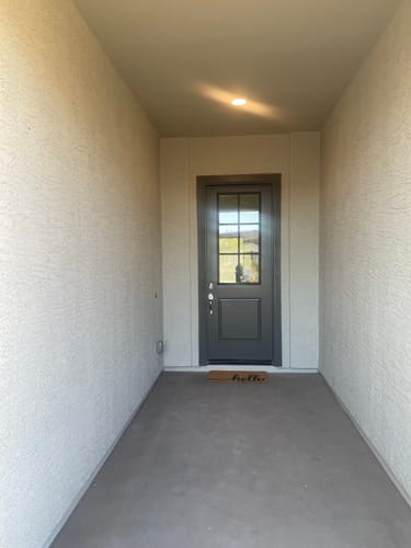Customer's gray entry door with the Clear 6 Lite Glass and Frame Kit installed, seen from the porch.