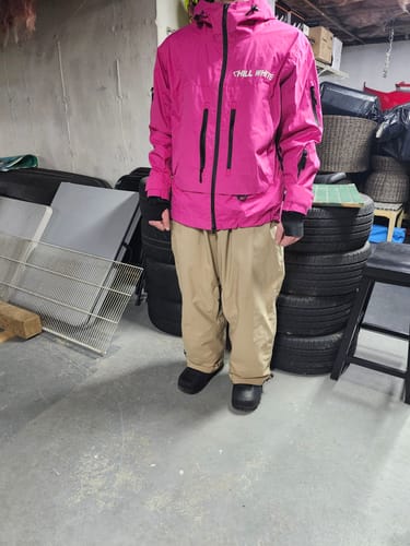 Reviewer standing indoors to show the baggy fit of the khaki-colored Snow Pants.