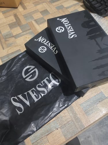 Customer's two black Sveston boxes and bag containing their Modicci watches, arranged on a surface.