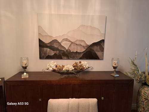 Reviewer's 'Neutral Mountain' Framed Canvas displayed on a wall over a dark wooden sideboard.