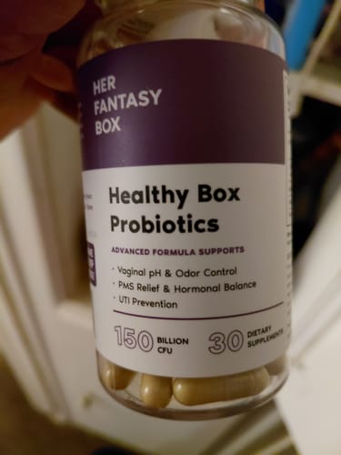 Customer holding a bottle of 'Healthy Box Probiotics' supplements from Her Fantasy Box.