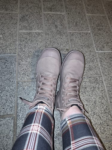 לקוח/ה מראה את מגפי ה-Pampa Hi Athletic שלה על רגליה.