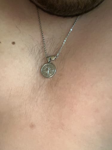 Cliente usando el Colgante de Compass plateado en su pecho.