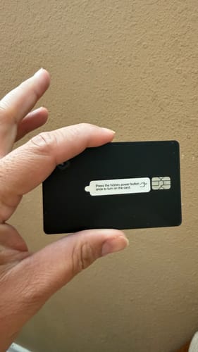 Customer holding the black SPOTMINDERS Tracking Card PRO, which is the size of a credit card.