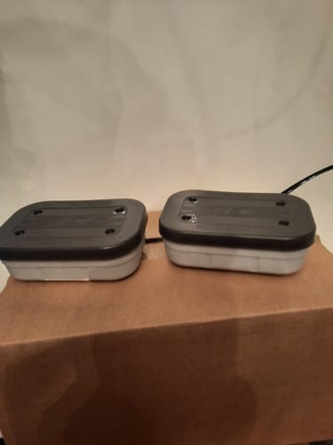 Recensent toont twee rechthoekige, lichtgrijze AIR LOCK BAIT TUBS op een doos.