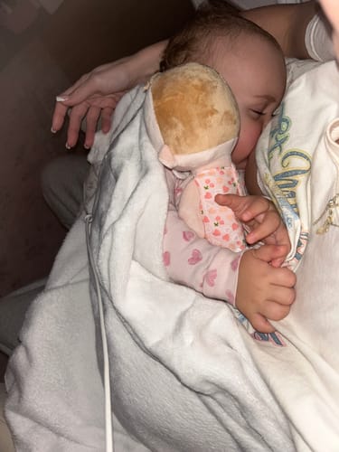 Customer's baby sleeping soundly while cuddling the soft Personalized Cherry Baby Girl doll.