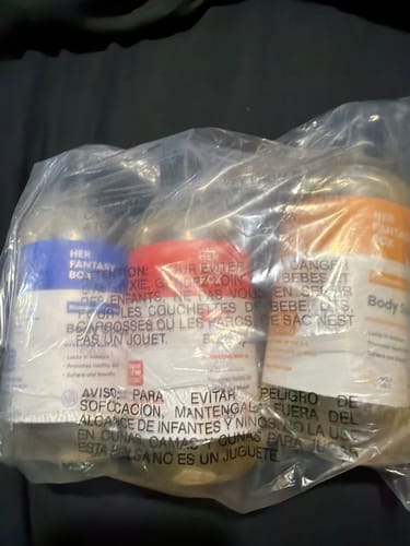 Close-up of a customer's Fruity Skin Body Oil Bundle, with three bottles visible inside their clear plastic packaging.