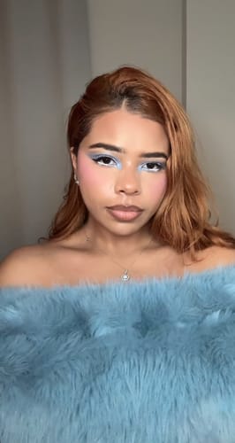 Reviewer wearing the off-shoulder, light blue faux fur top that matches the Faux Fur Pelted Mini Skirt.